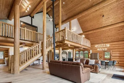 a large living room with wooden ceilings and a staircase at Nordegg Timber Estate in Nordegg