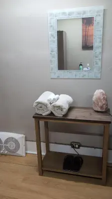 a table with towels on it with a mirror at Tania's guest rooms in Calgary