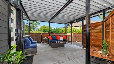 a pergola on a patio with chairs and a table at Knockan Hill Rentals - Garden Suite in Victoria