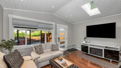 a living room with a flat screen tv and a couch at Knockan Hill Rentals - Garden Suite in Victoria