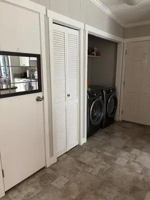 a laundry room with a washing machine and a washer at Golfers getaway home in the trees in Roberts Creek