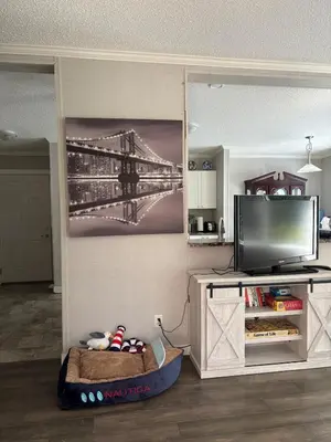a living room with a tv and a painting of a bridge at Golfers getaway home in the trees in Roberts Creek
