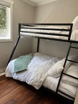 a bedroom with two bunk beds and a bed at Golfers getaway home in the trees in Roberts Creek