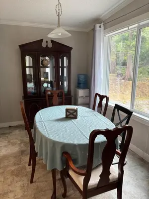 a dining room with a table and a window at Golfers getaway home in the trees in Roberts Creek