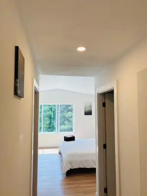 a bedroom with a bed and a window at Castle BNB 2025 in Gibsons