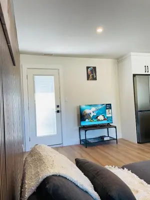 a living room with a flat screen tv on a table at Castle BNB 2025 in Gibsons