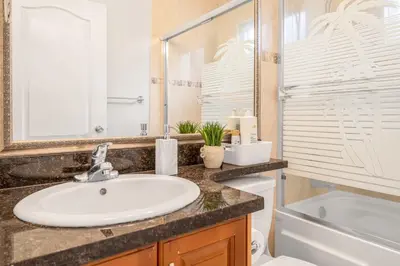 a bathroom with a sink and a toilet and a mirror at Central Spacious 3 Br Upstairs in Vancouver