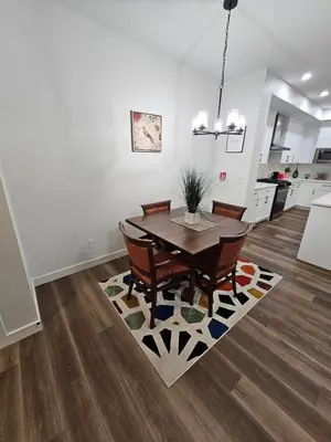 a dining room with a table and chairs on a rug at Family Friendly in Calgary