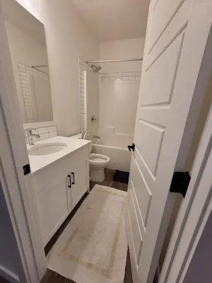 a bathroom with a sink and a toilet and a door at Family Friendly in Calgary