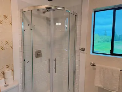 a shower with a glass door in a bathroom at Sunshine garden 5 bedrooms2 living rooms3 bathrooms1 kitchen in Aldergrove