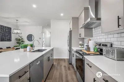 a kitchen with white cabinets and a counter top at Executive Single Detached House with AC King Bed and More in Calgary