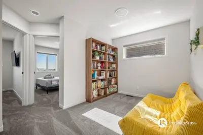 a living room with a couch and a book shelf at Executive Single Detached House with AC King Bed and More in Calgary