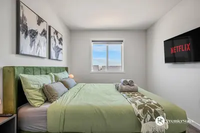 a bedroom with a bed with a teddy bear on it at Executive Single Detached House with AC King Bed and More in Calgary