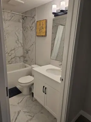 a bathroom with a sink and a toilet and a tub at Guest Suite in Southwest Calgary in Calgary