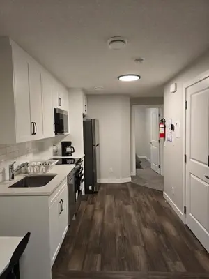a kitchen with a sink and a refrigerator at Guest Suite in Southwest Calgary in Calgary