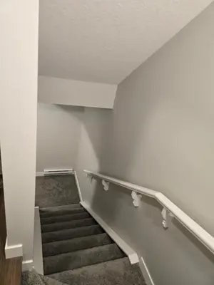 a staircase in a building with white walls and carpet at Guest Suite in Southwest Calgary in Calgary