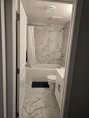 a bathroom with a toilet and a tub and a sink at Guest Suite in Southwest Calgary in Calgary