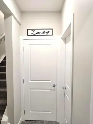 a white door in a hallway with a sign above it at Guest Suite in Southwest Calgary in Calgary