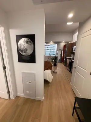 a living room with a picture of the moon on the wall at Boho Studio Downtown Rogers Views Heated Parking in Edmonton