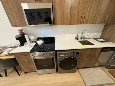 a kitchen with a stove and a sink and a dishwasher at Boho Studio Downtown Rogers Views Heated Parking in Edmonton