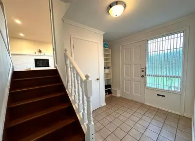 a staircase in a home with a white door at Cozy 3 Bedrooms with Kitchen and Laundry Near Airport in Richmond