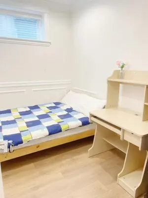 a small bedroom with a bed and a desk at Cozy New Suite 8mins to Downtown in Vancouver
