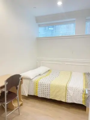 a bedroom with two beds and a desk and a window at Cozy New Suite 8mins to Downtown in Vancouver