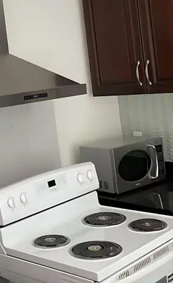 a microwave sitting on top of a stove in a kitchen at Cozy New Suite 8mins to Downtown in Vancouver