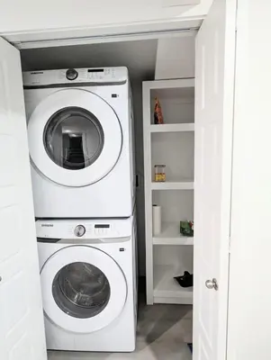 a washer and dryer in a white laundry room at Basement Suite in Desrochers SW in Edmonton