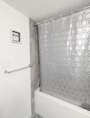 a shower in a bathroom with a shower curtain at Basement Suite in Desrochers SW in Edmonton