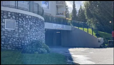a large building with a garage and a balcony at Quiet & Cozy Ski-In Out, Hot tub, pool in Whistler