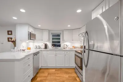a kitchen with white cabinets and a refrigerator at Prestigious 2 Bedrooms 2 Baths in West Point Grey in Vancouver