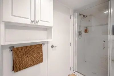a bathroom with a shower and a white cabinet at Prestigious 2 Bedrooms 2 Baths in West Point Grey in Vancouver