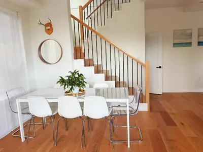 a dining room with a white table and white chairs at Roger & May's Cabin in Vancouver
