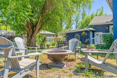 a group of chairs and a table and a tree at Blue Spruce Den - Vernon in Vernon