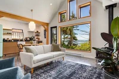 a living room with a couch and a large window at Fogged Inn in Ucluelet