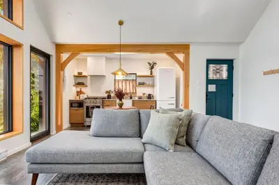 a living room with a couch and a kitchen at Fogged Inn in Ucluelet