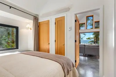 a bedroom with a bed and a view of the ocean at Fogged Inn in Ucluelet