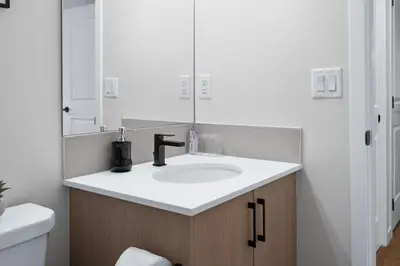 a bathroom with a sink and a mirror at Cozy 2BR Suite with Kitchen, AC Near U of C, Winsport, Banff and Hospitals in Calgary