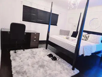 a bedroom with a bed and a dog laying on a rug at Private 2 BR Cozy Home Private Parking Free Sparkling and Goodies! 4 mins from Metrotown in Burnaby