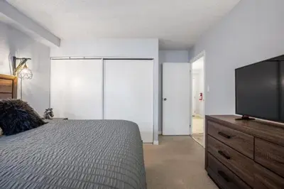 a bedroom with a bed and a flat screen tv at Cozy & Spacious 2BR in Downtown very close to Stampede and 17th Ave with Parking and AC in Calgary