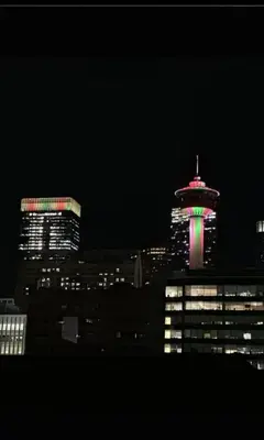 a night view of a city with a tower with a green light at Cozy & Spacious 2BR in Downtown very close to Stampede and 17th Ave with Parking and AC in Calgary
