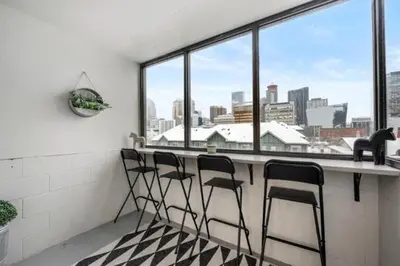 a bar with four chairs in front of a window at Cozy & Spacious 2BR in Downtown very close to Stampede and 17th Ave with Parking and AC in Calgary
