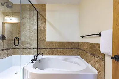 a bathroom with a bath tub and a shower at Creekside at Rundle Cliffs Lodge in Canmore