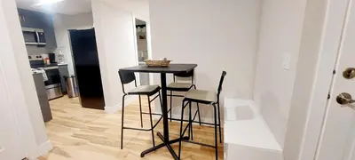 a small black table in a kitchen with two stools at Little Heaven 2BR southwest Calgary in Calgary