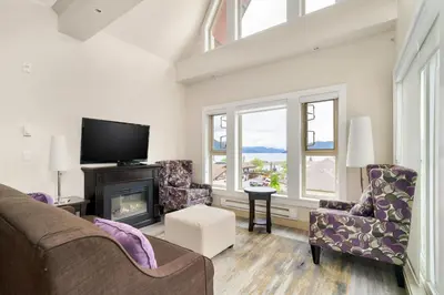 a living room with a fireplace and a tv at Scenic 3BR unit in Harrison in Harrison Hot Springs