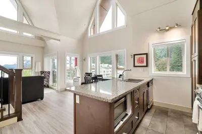 a kitchen with a large island in a room with windows at Scenic 3BR unit in Harrison in Harrison Hot Springs