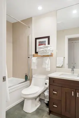 a white bathroom with a toilet and a sink at Scenic 3BR unit in Harrison in Harrison Hot Springs