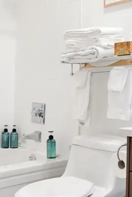 a bathroom with a toilet and a sink and towels at 4BR Unit In The Heart Of Harrison in Harrison Hot Springs