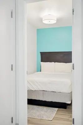 a bedroom with a bed through a sliding door at 4BR Unit In The Heart Of Harrison in Harrison Hot Springs